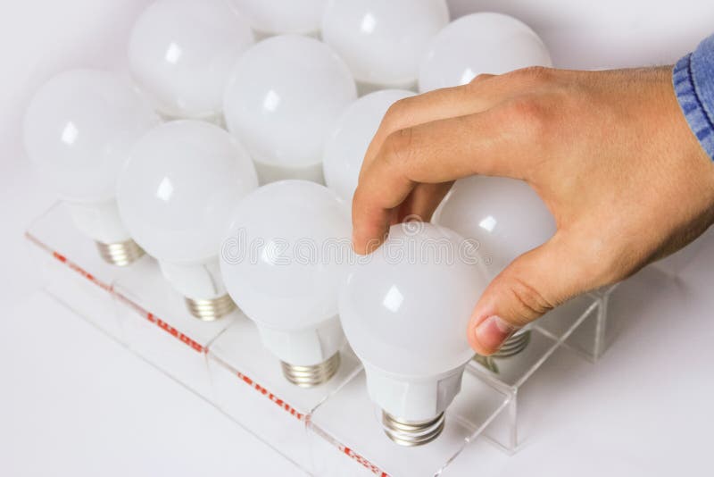 Many led lamps. man`s hand unscrews the light bulb