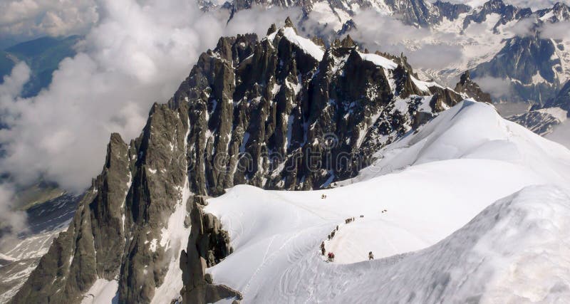 Mountain climbers descending from the Aiguille du Midi into the Mont Blanc mountains near Chamonix in the French Alps. Mountain climbers descending from the Aiguille du Midi into the Mont Blanc mountains near Chamonix in the French Alps