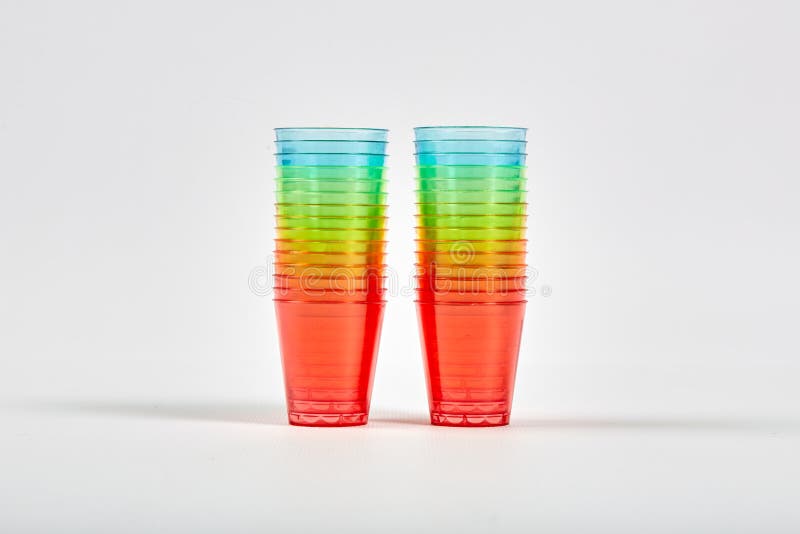 Many Multicolored Rainbow Colored Plastic Glasses are Stacked Together