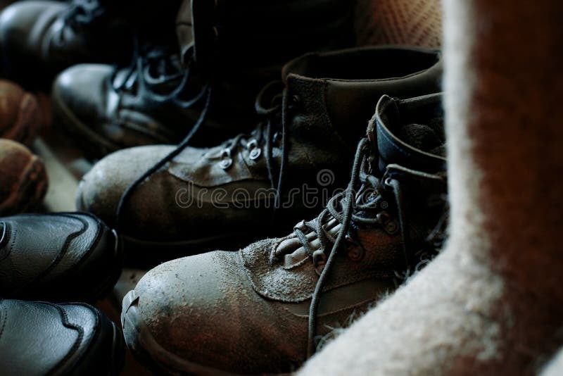 Many Old Work Boots Stand Together. Old Worn Construction Boots of