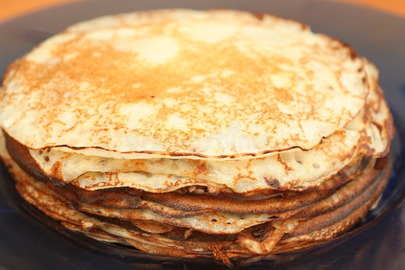 Many pancakes lay in a plate