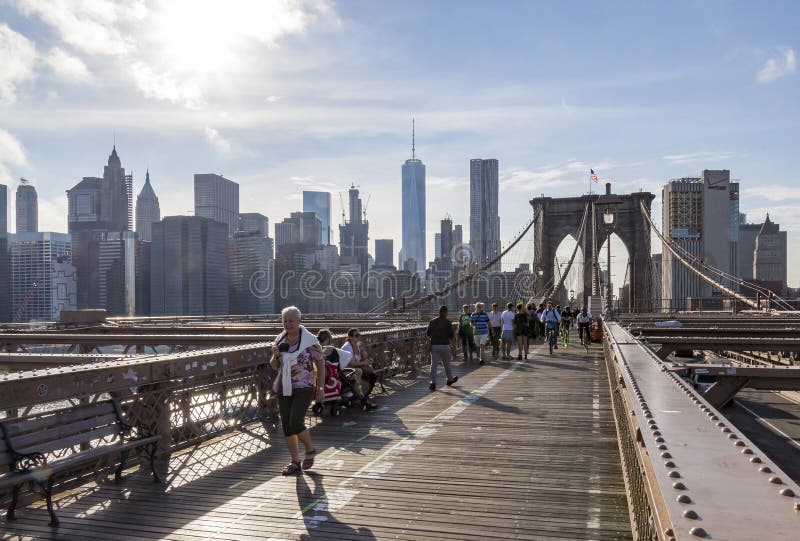 Many pedestrians and cyclists on the upper deck of the Brooklyn Bridge with Manhattan in the background, New York, United States royalty free stock image Many pedestrians and cyclists on the upper deck of the Brooklyn Bridge with Manhattan in the background, New York, United States royalty free stock image