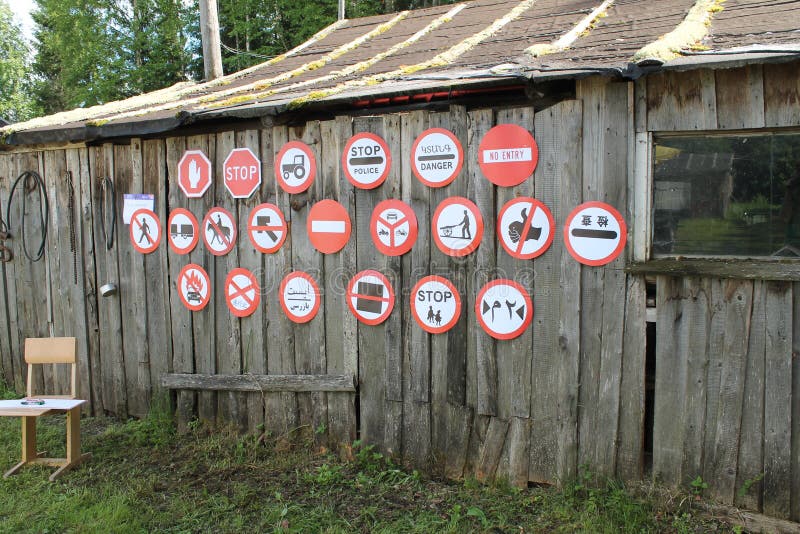 Many road signs hang on the wall of a wooden rural building with a window. Contemporary art design. Syktyvkar, Russia. Barkemp stock photos Many road signs hang on the wall of a wooden rural building with a window. Contemporary art design. Syktyvkar, Russia. Barkemp stock photos