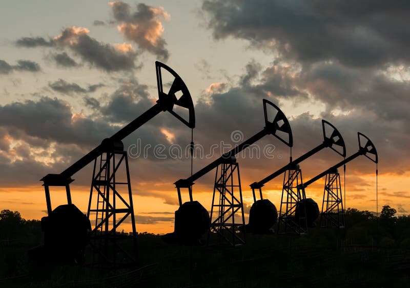 Many silhouettes of drilling oil rigs at sunset.