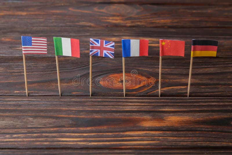 Many small paper flags of different countries on wooden table royalty free stock photos