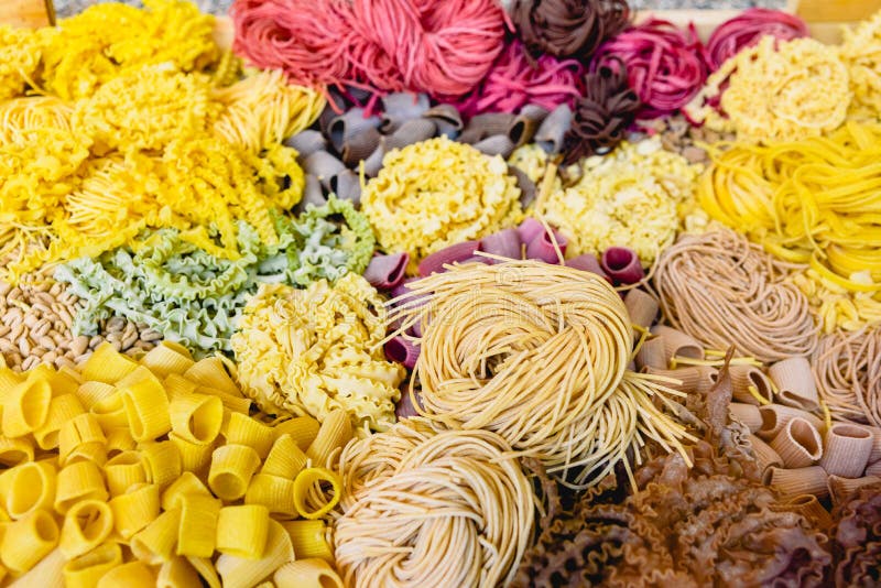 Many Types of Uncooked Italian Pasta of Various Colors and Shapes Stock