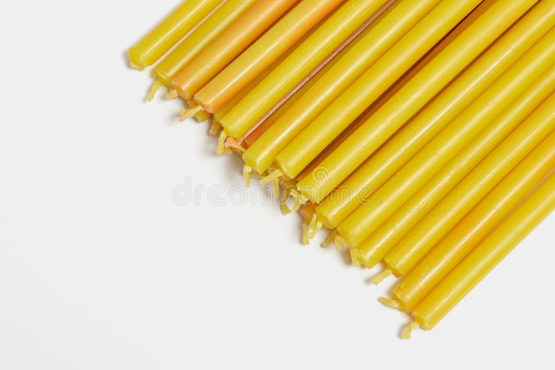 many yellow church candles on white background