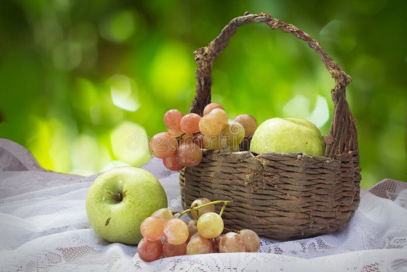 Manzanas y uvas verdes con la cesta vieja imagenes de archivo Manzanas y uvas verdes con la cesta vieja imagenes de archivo