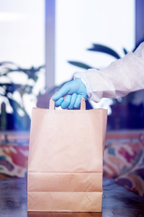 Man’s hand holding bags of groceries during coronavirus pandemic. COVID-19 concept