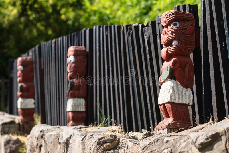 Maori Wood Carving Nya Zeeland Rad av krigarediagram mot ett staket royaltyfria bilder Maori Wood Carving Nya Zeeland Rad av krigarediagram mot ett staket royaltyfria bilder