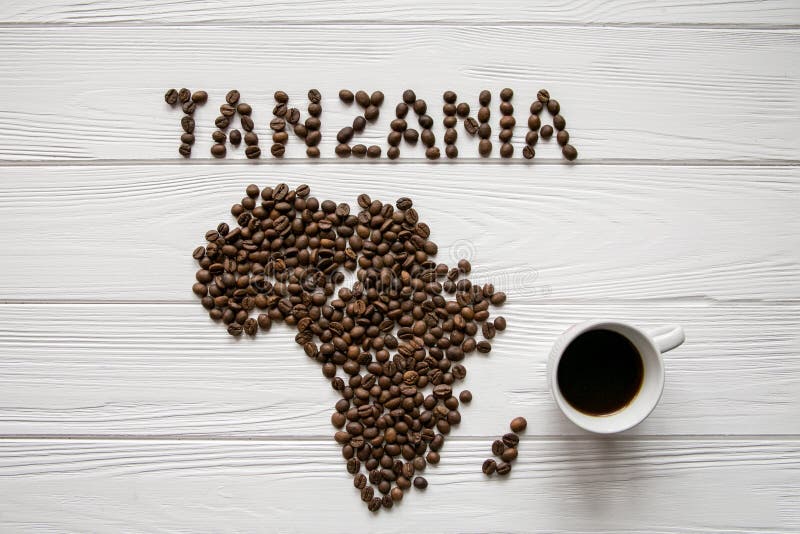 Map of the Tanzania made of roasted coffee beans layin on white wooden textured background with coffee cup royalty free stock photo Map of the Tanzania made of roasted coffee beans layin on white wooden textured background with coffee cup royalty free stock photo