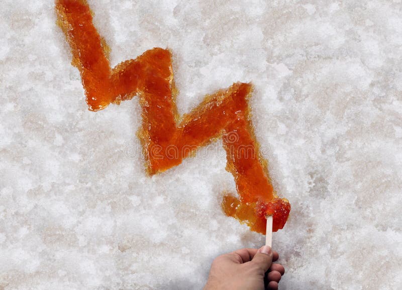 Maple syrup shortage and decline of Sugar Shack Maple taffy or sweet boiled tree sap as a downward chart arrow on snow as a traditional spring season food culture from Quebec Ontario Canada and New England