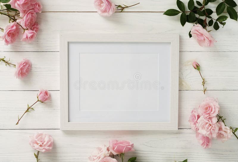 Poster frame mockup, top view, pink roses on white wooden background.Holiday concept.Copy space. Poster frame mockup, top view, pink roses on white wooden background.Holiday concept.Copy space