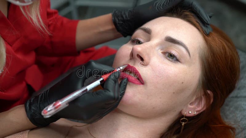 Maquillage permanent. traitement de beauté spa. jeune femme. tatouage sur le visage. incliner clips vidéos