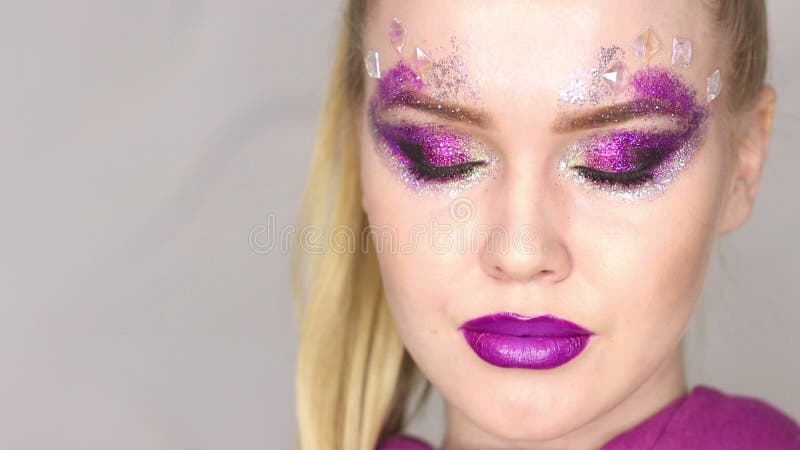 Maquillaje de la belleza Maquillaje púrpura y clavos brillantes coloridos Retrato hermoso del primer de la muchacha almacen de metraje de vídeo
