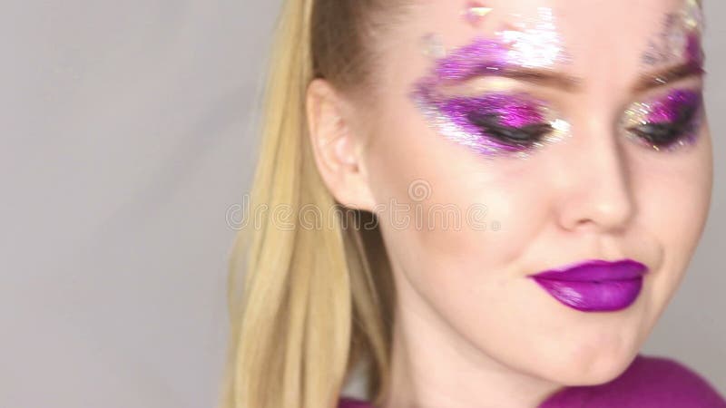 Maquillaje de la belleza Maquillaje púrpura y clavos brillantes coloridos Retrato hermoso del primer de la muchacha almacen de video