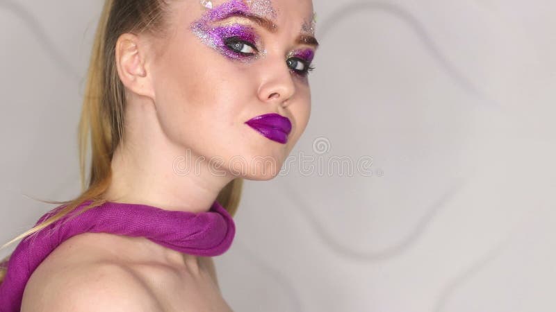 Maquillaje de la belleza Maquillaje púrpura y clavos brillantes coloridos Retrato hermoso del primer de la muchacha almacen de metraje de vídeo