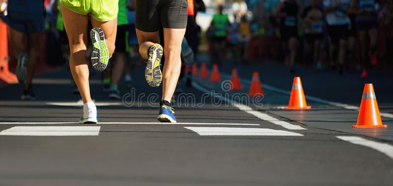 Maratonlöpare som kör på stadsvägen, detalj på ben royaltyfri bild Maratonlöpare som kör på stadsvägen, detalj på ben royaltyfri bild