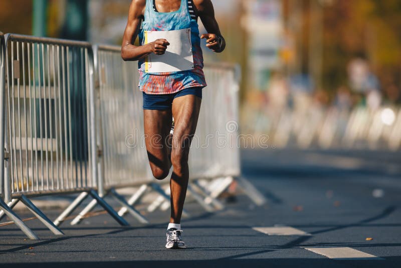 Maratonspringlopp, afrikansk kvinnafot på höstvägen Afrikansk löpare som kör stads- maraton i staden arkivbilder Maratonspringlopp, afrikansk kvinnafot på höstvägen Afrikansk löpare som kör stads- maraton i staden arkivbilder
