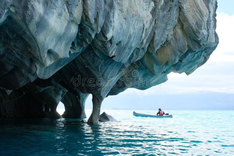 Marble caverns over blue water with canoe, Chile stock photo Marble caverns over blue water with canoe, Chile stock photo