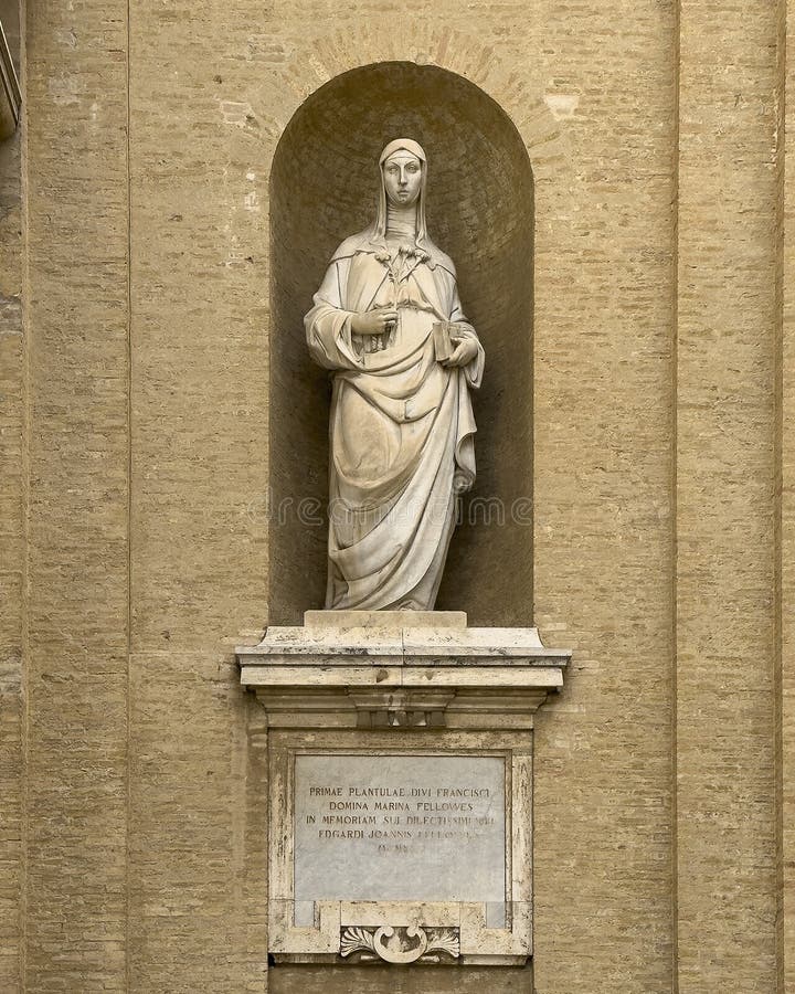 Pictured is a marble statue of Saint Clare of Assisi on the right front of the Basilica of Saint Mary of the Angels in Assisi, Italy. In her right hand are lilies, the symbol of her purity and virginity, which in the left is a book. The basilica is located outside the city walls, 3 kilometers from the historical center. The basilica was constructed in the Mannerist style between 1569 and 1679, enclosing the 9th-century little church, the Porziuncola, the most sacred place for the Franciscans. Pictured is a marble statue of Saint Clare of Assisi on the right front of the Basilica of Saint Mary of the Angels in Assisi, Italy. In her right hand are lilies, the symbol of her purity and virginity, which in the left is a book. The basilica is located outside the city walls, 3 kilometers from the historical center. The basilica was constructed in the Mannerist style between 1569 and 1679, enclosing the 9th-century little church, the Porziuncola, the most sacred place for the Franciscans.