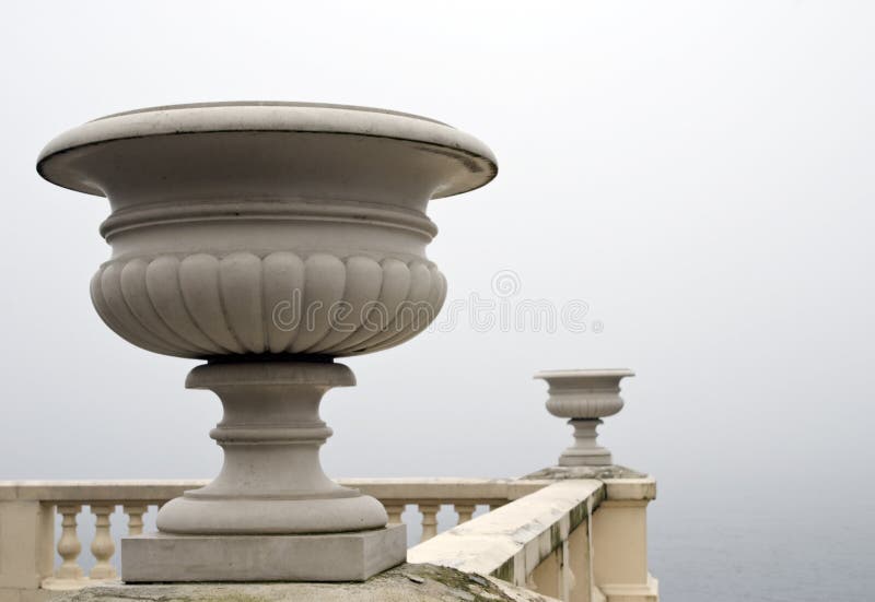 Marble vase. A morning fog above lake.