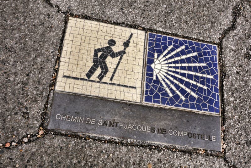 Way of St James Route leading to Santiago de Compostela sidewalk marker in French as Saint Jacques de Compostelle marking a station of the Christian catholic pilgrimage itinerary in France. Way of St James Route leading to Santiago de Compostela sidewalk marker in French as Saint Jacques de Compostelle marking a station of the Christian catholic pilgrimage itinerary in France