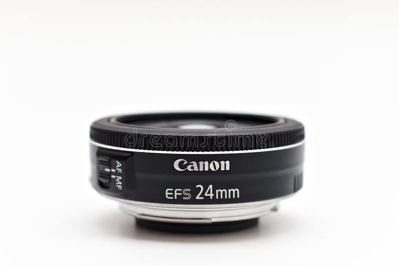 Kiev, Ukraine - March 05th, 2021: Canon EF-S 24 mm STM lens for digital SLR crop cameras with the logo facing forward. Close up studio photo. Kiev, Ukraine - March 05th, 2021: Canon EF-S 24 mm STM lens for digital SLR crop cameras with the logo facing forward. Close up studio photo