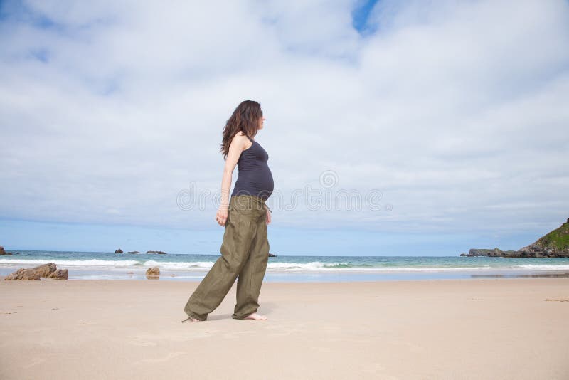 Marche enceinte de chemise grise à côté de l'océan photo stock