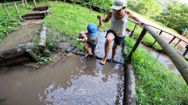 Marcher pieds nus dans la boue et l'eau dans un parc sensoriel pour profiter de la nature banque de vidéos