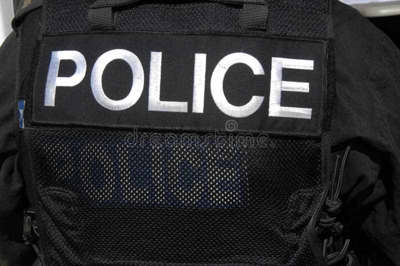 Marchio della POLIZIA sulla maglia dell'ufficiale dello SCHIAFFO. fotografie stock Marchio della POLIZIA sulla maglia dell'ufficiale dello SCHIAFFO. fotografie stock