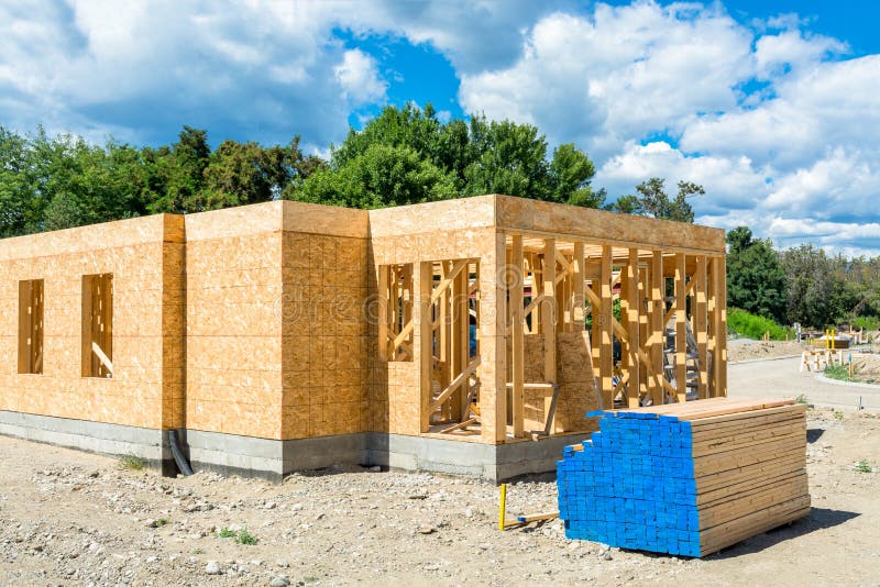 Marco de madera del nuevo edificio con los materiales de la madera de construcci?n preparados para la construcci?n fotografía de archivo Marco de madera del nuevo edificio con los materiales de la madera de construcci?n preparados para la construcci?n fotografía de archivo