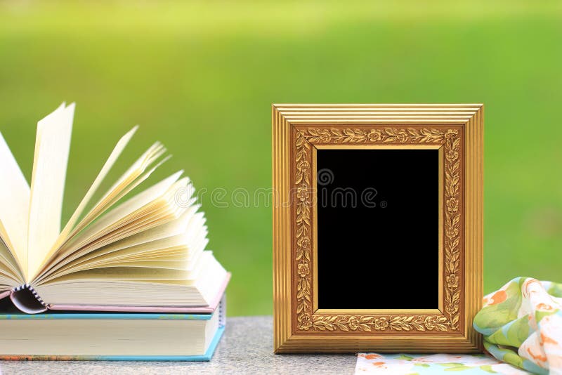 Marco de oro con los libros en la tabla de madera imagenes de archivo Marco de oro con los libros en la tabla de madera imagenes de archivo