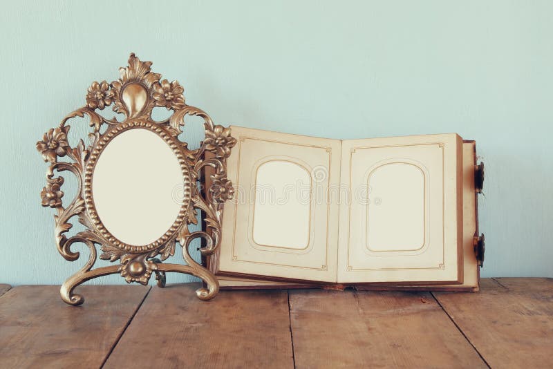 Marco en blanco antiguo del estilo del victorian y álbum de fotografía abierto viejo en la tabla de madera imagen filtrada retra imágenes de archivo libres de regalías Marco en blanco antiguo del estilo del victorian y álbum de fotografía abierto viejo en la tabla de madera imagen filtrada retra imágenes de archivo libres de regalías