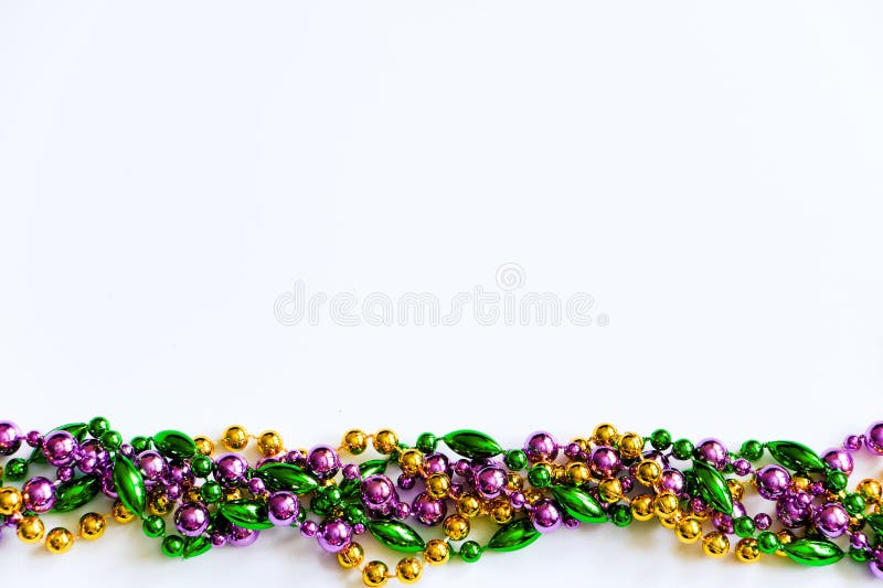 Mardi Gras background. Gold, green and purple beads on white background. Fat Tuesday symbol.