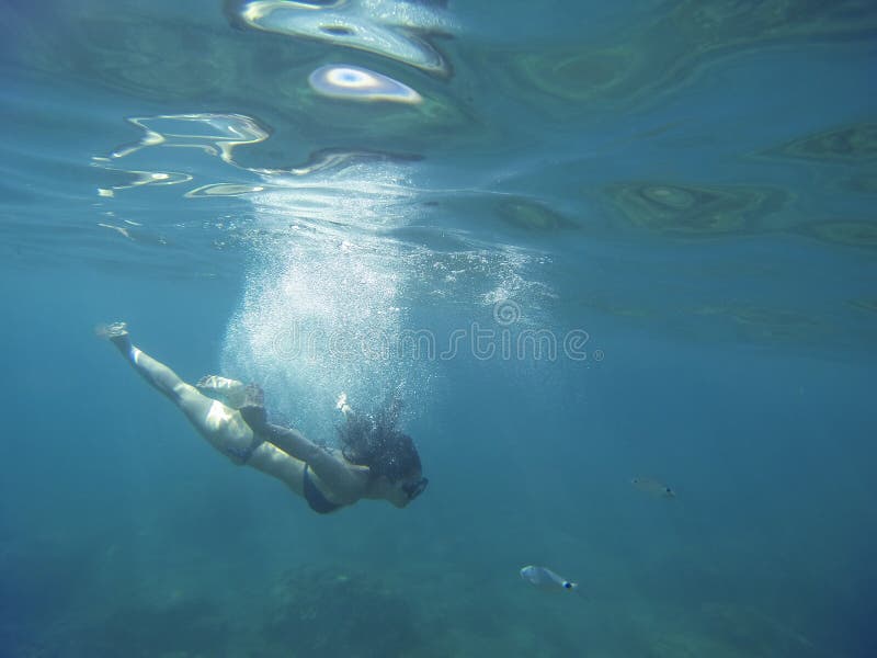 Mare strabiliante del turchese con un'immersione con bombole della giovane donna