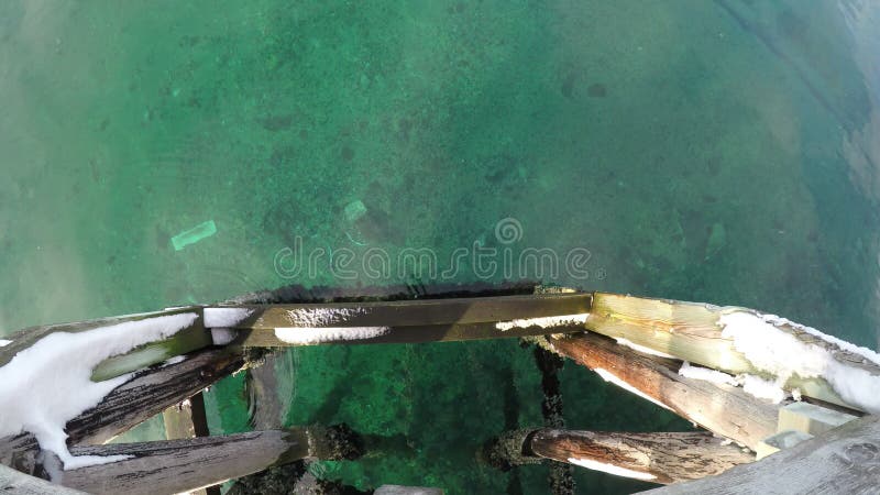 Mare verde calmo con il vecchio pilastro di legno variopinto video d archivio