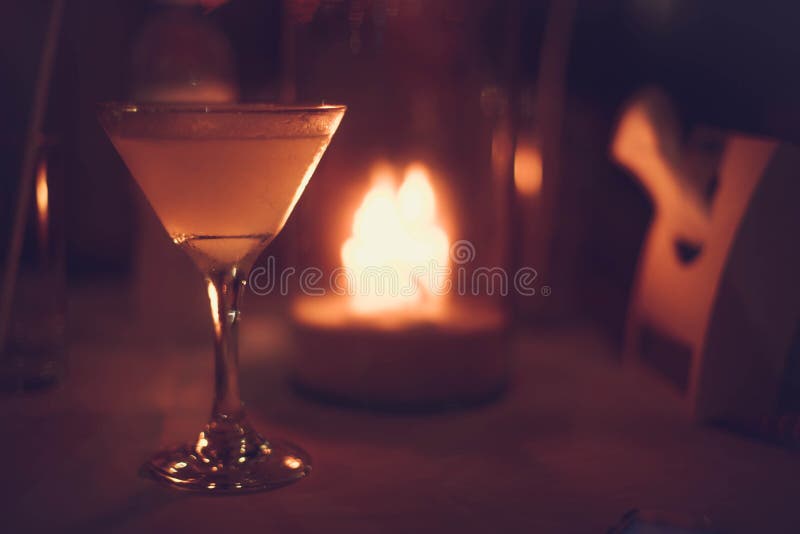 Margarita heló el cóctel en los vidrios de martini delante de las luces del bokeh de la noche en fondo borroso de la vela foto de archivo libre de regalías Margarita heló el cóctel en los vidrios de martini delante de las luces del bokeh de la noche en fondo borroso de la vela foto de archivo libre de regalías
