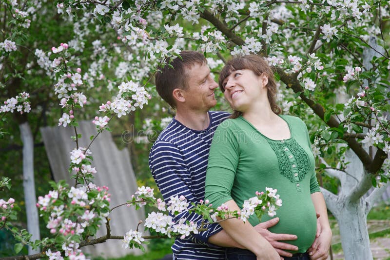 Mari et son jardin de floraison enceinte d'épouse au printemps photographie stock Mari et son jardin de floraison enceinte d'épouse au printemps photographie stock