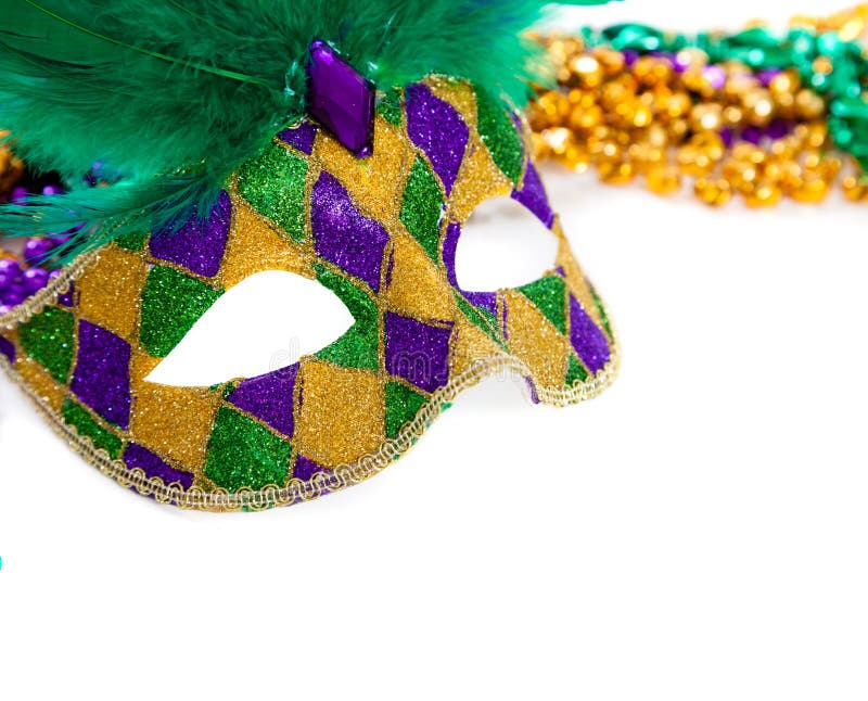 A purple, gold and green mardi gras mask and beads on white. A purple, gold and green mardi gras mask and beads on white