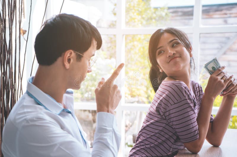 Marido irritado na esposa ávida que rouba o dinheiro foto de stock Marido irritado na esposa ávida que rouba o dinheiro foto de stock