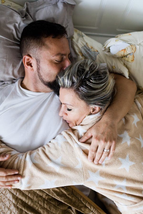 Marido y esposa que duermen junto en una cama - en abrazo fotografía de archivo libre de regalías Marido y esposa que duermen junto en una cama - en abrazo fotografía de archivo libre de regalías