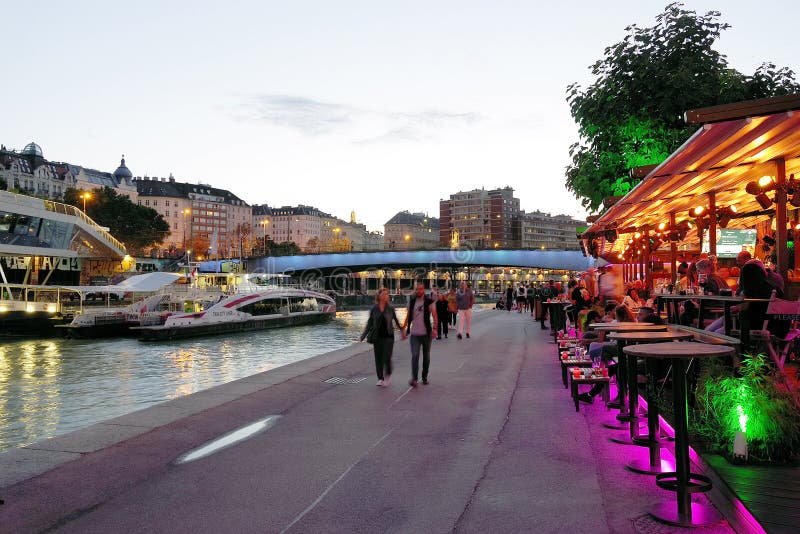 VIENA, AUSTRIA, 15 SEPTEMBER, 2019: Evening lights in Viena. Promenade on Donaukanal. Marienbrucke in background.