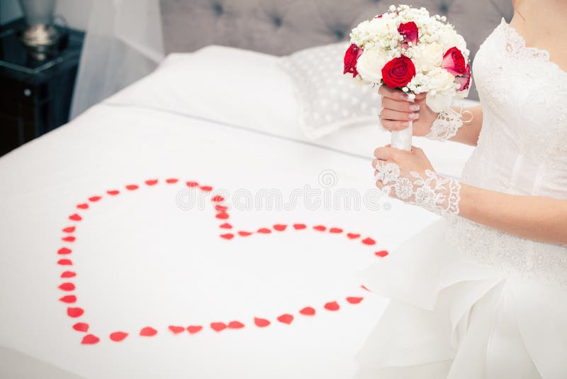 Mariez, mariage Jeune mariée à la maison Lit nuptiale Forme de coeur de pétales image stock Mariez, mariage Jeune mariée à la maison Lit nuptiale Forme de coeur de pétales image stock