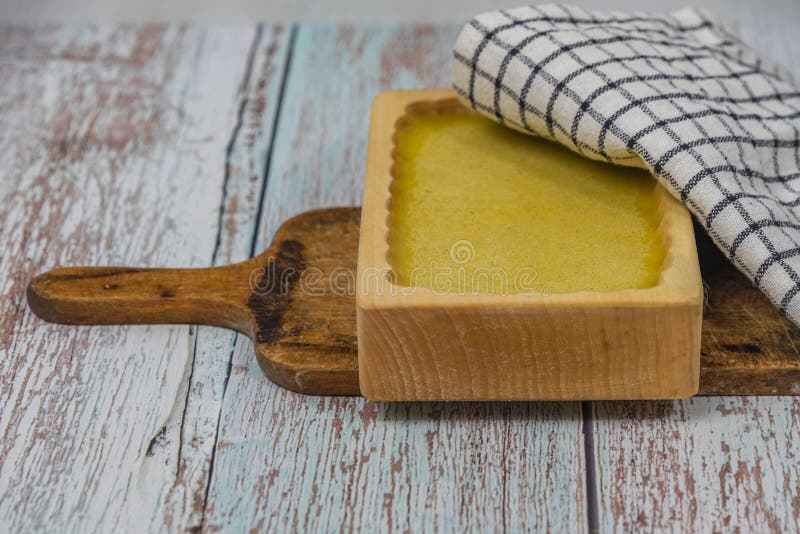 Marijuana butter with wooden mould on blue old table with checker dish towel