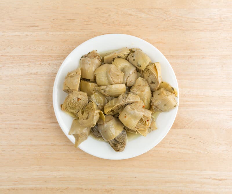 Marinated artichoke hearts on a plate atop a table