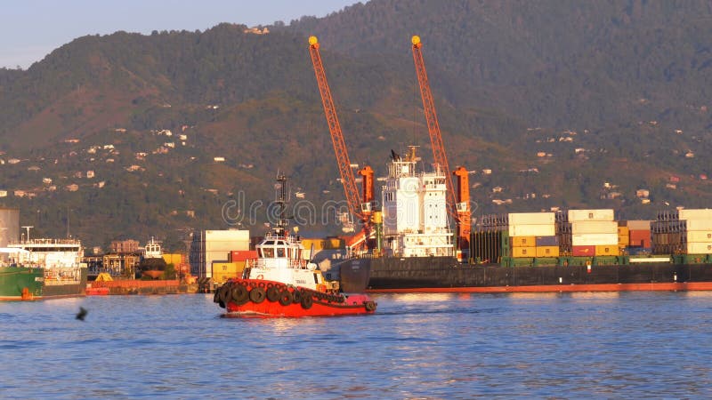 Marine Port of Batumi with Cranes, barges and ships in the sea against the backdrop of the mountains