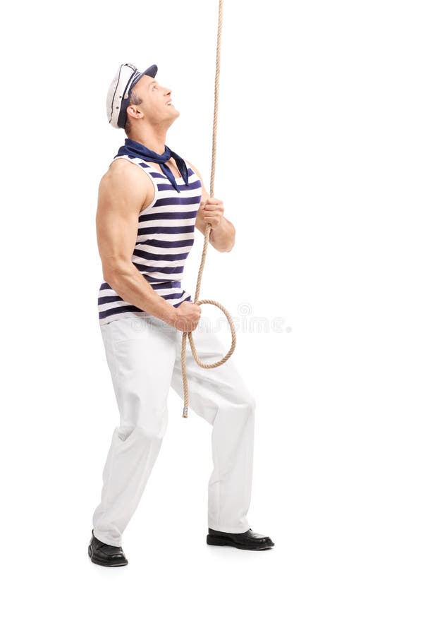 Marinheiro masculino novo que puxa uma corda e que olha acima fotografia de stock Marinheiro masculino novo que puxa uma corda e que olha acima fotografia de stock