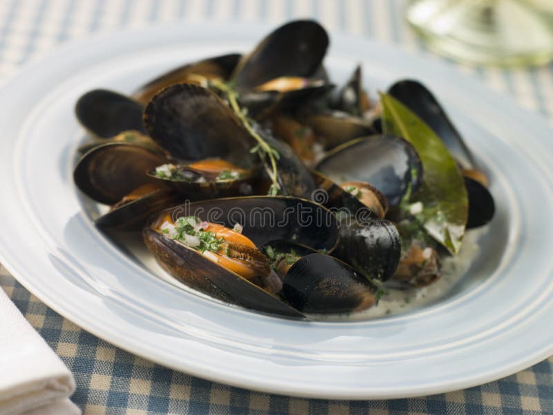 Plate of Moules Mariniere on a dish on table. Plate of Moules Mariniere on a dish on table
