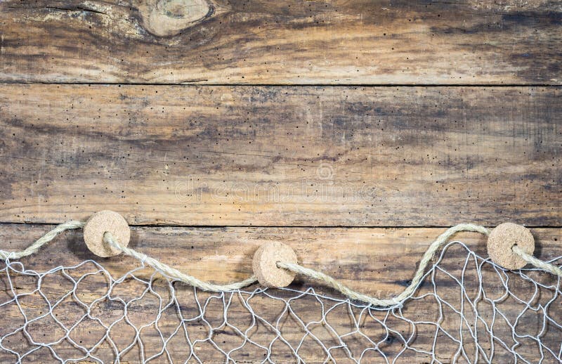 Fishing net with sea shells and fish decoration on old brown wooden boards and place for text. Fishing net with sea shells and fish decoration on old brown wooden boards and place for text.